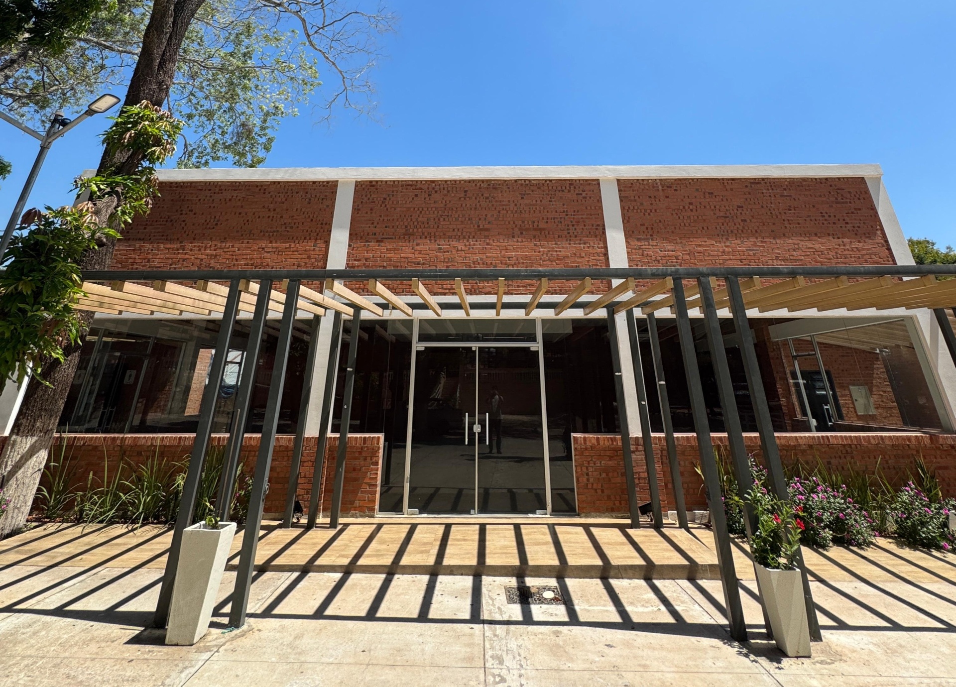 Fachada del salón de eventos AFEMEC con pérgola de madera
