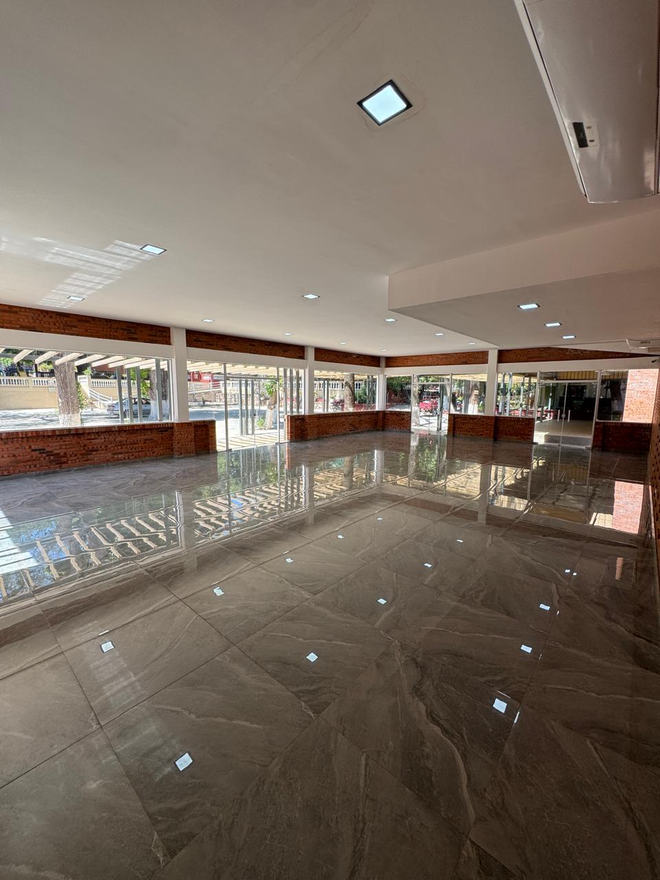 Interior del salón con pisos pulidos y ventanales