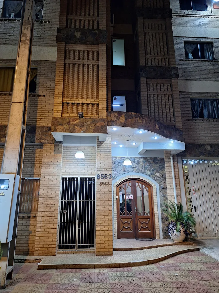 Ingreso nocturno del Hotel de las Orquídeas con fachada de ladrillo y piedra