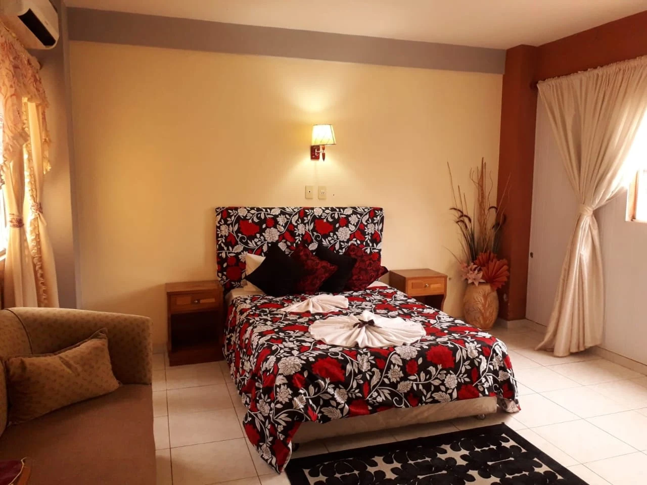 Habitación del Hotel de las Orquídeas con cama matrimonial y decoración cálida