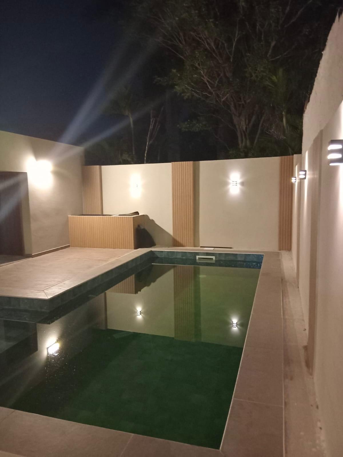Piscina exterior con iluminación nocturna