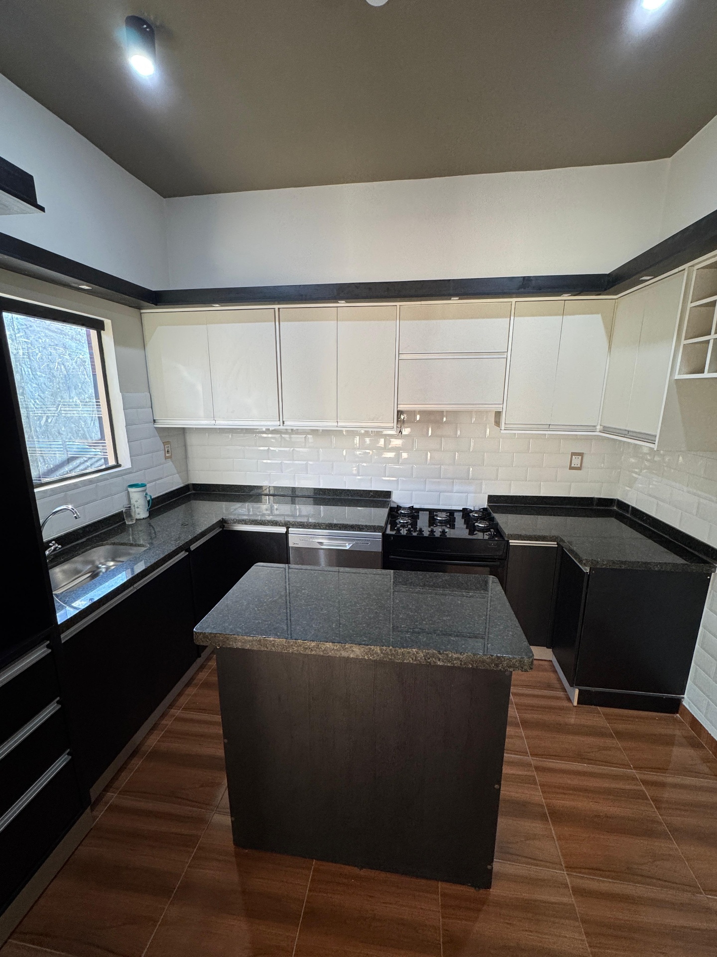 Cocina con isla de granito y mobiliario a medida